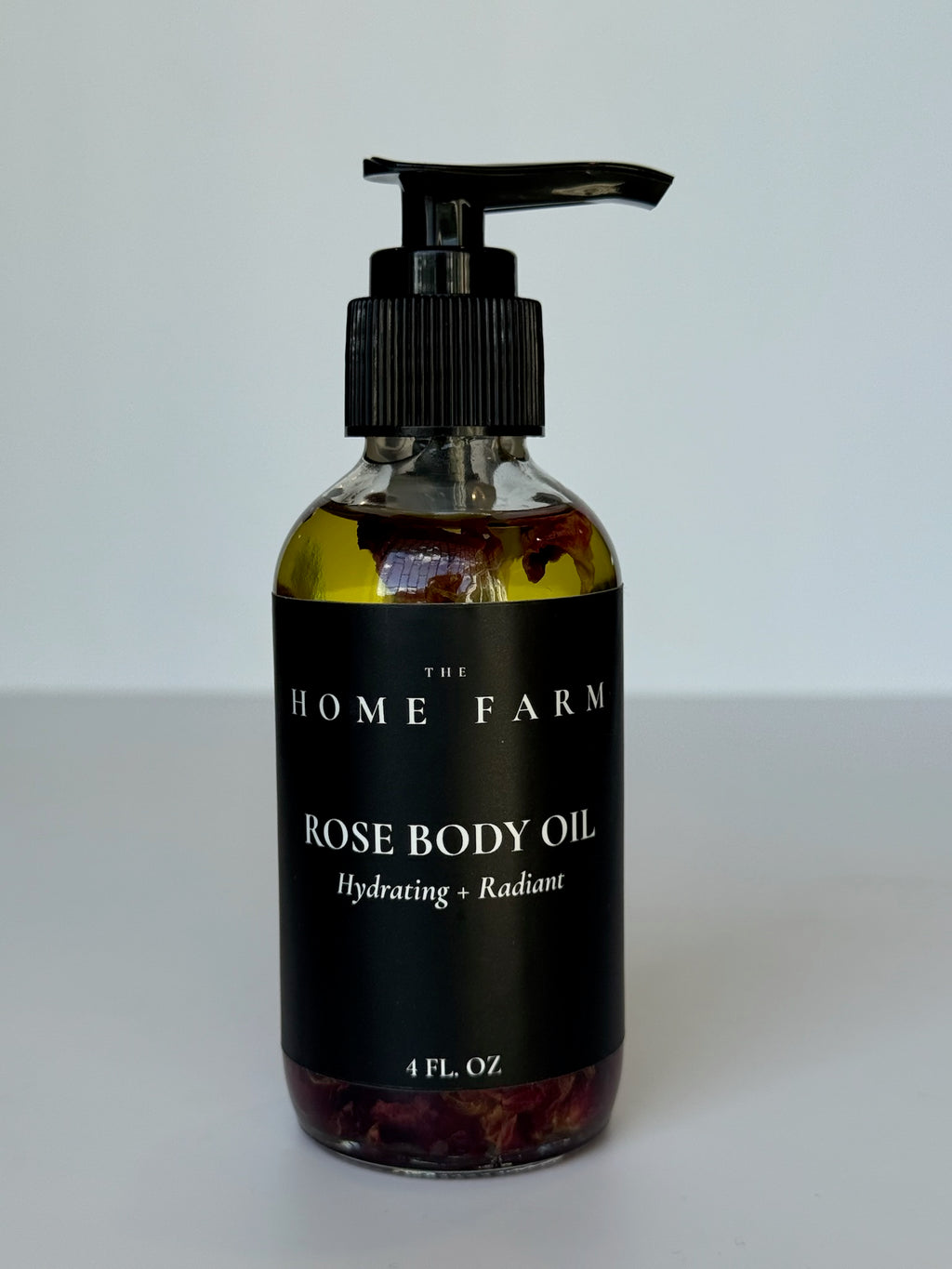 Woman applying rose body oil to arm showing improved skin radiance