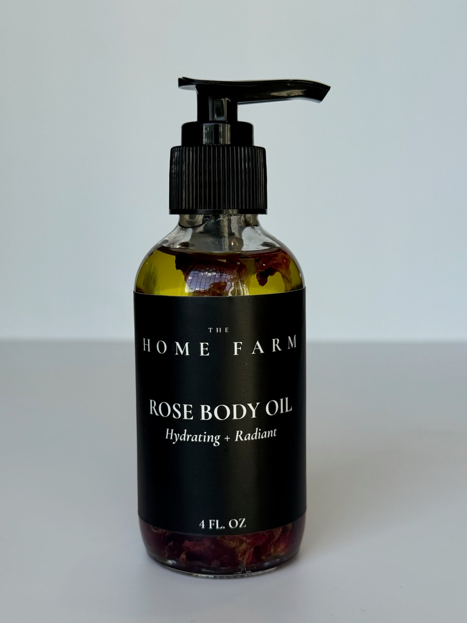 Woman applying rose body oil to arm showing improved skin radiance